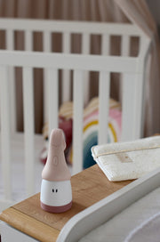 Beaba Pixie Torch standing beside a cot