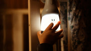 Hand touching the illuminated Beaba Pixie Torch